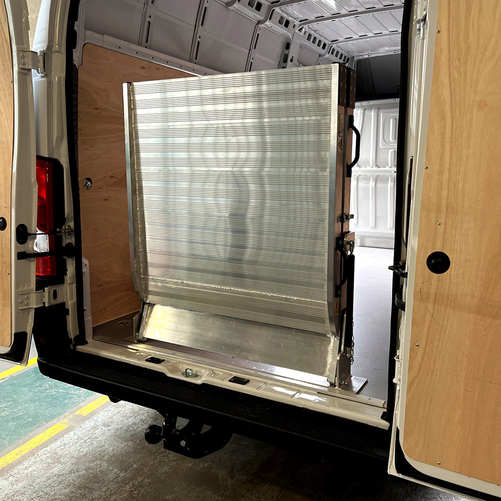 Picture of a folding van ramp folded upright in a van. Fixed folding van ramp fitted to a van.